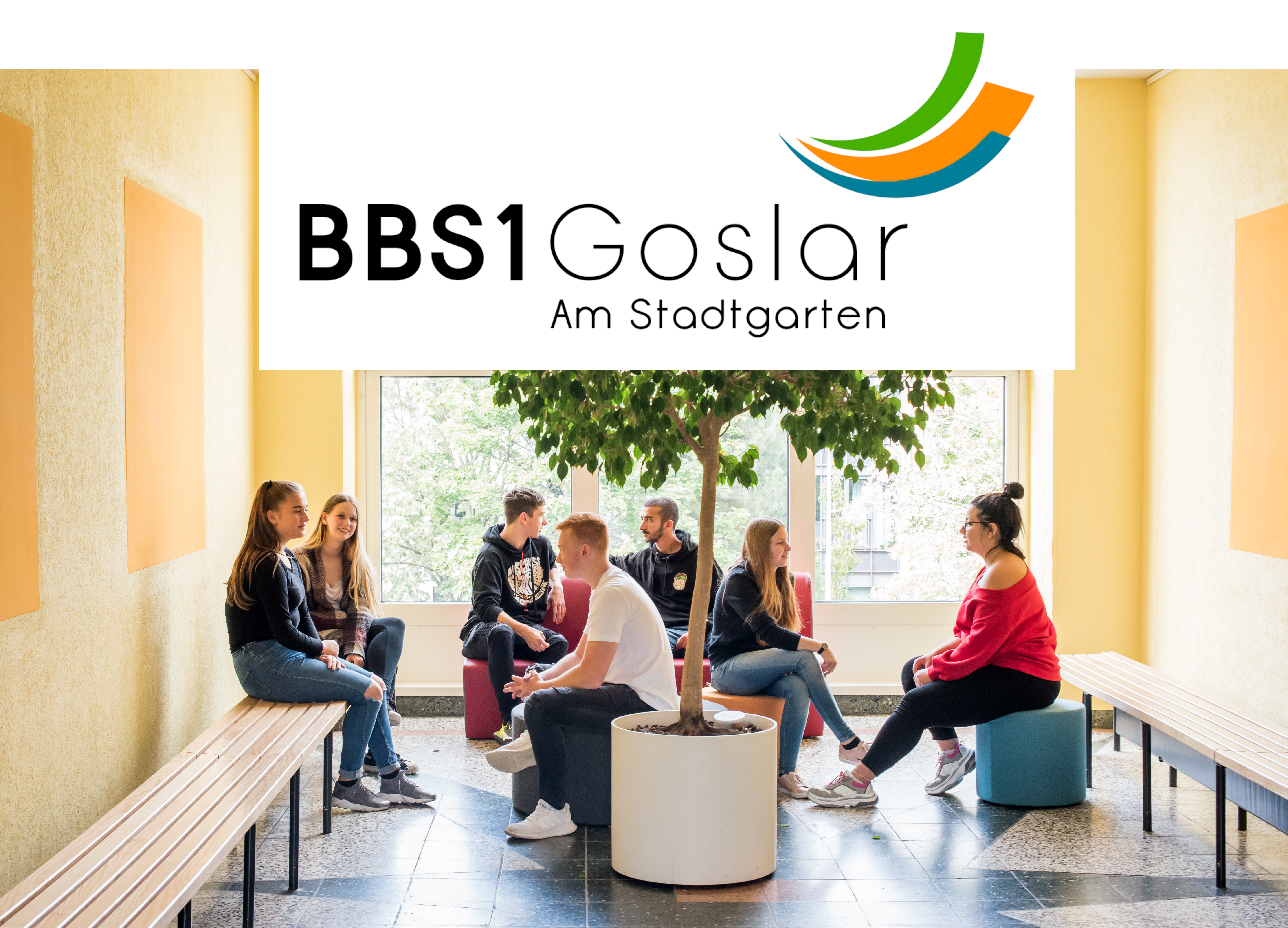 Schul-Logo vor Sitzecke mit Baum